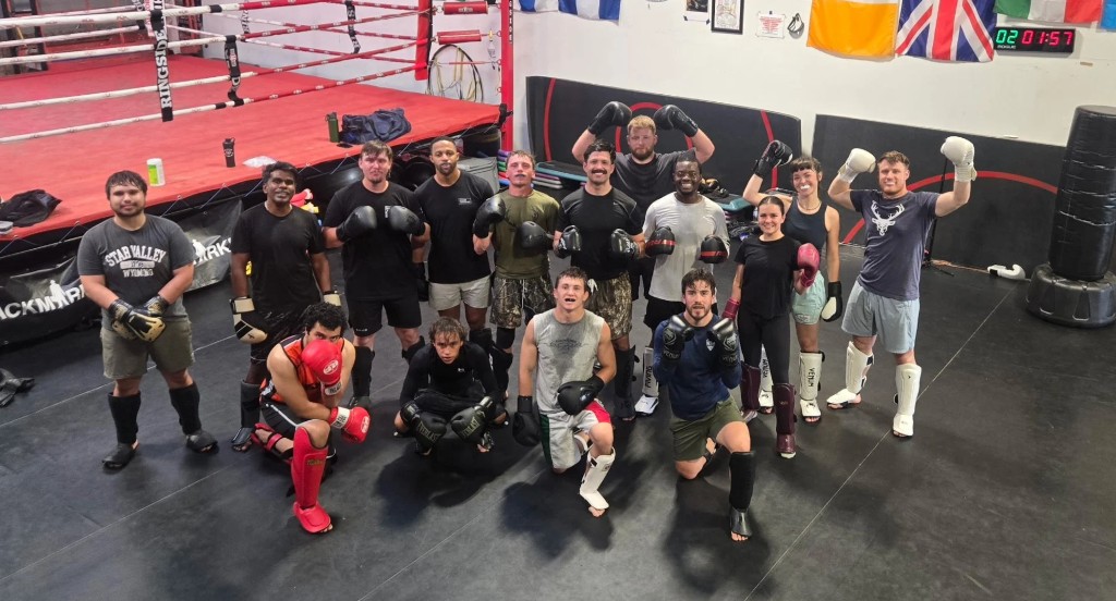 Three Pillars striking class posing with boxing gloves